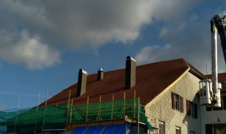 Garniture de cheminée en aluminium brun et toiture tuile à Métabief